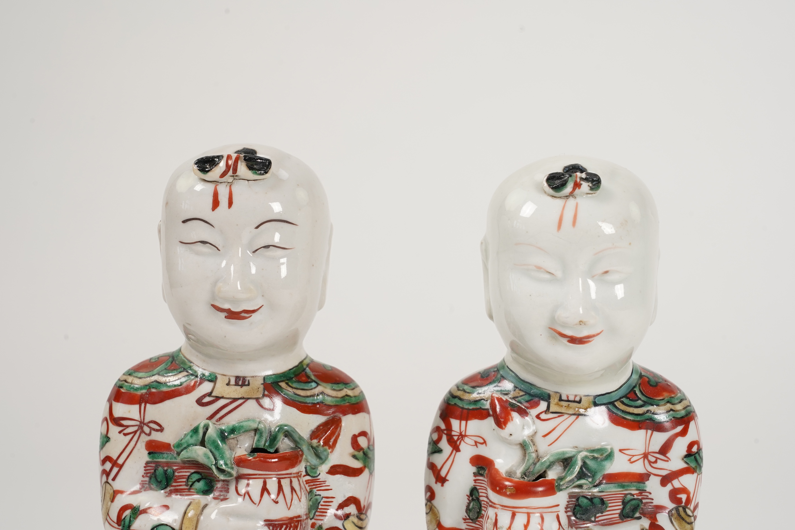 A pair of Chinese famille verte figures of smiling boys, Kangxi period